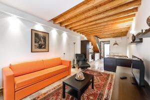 a living room with an orange couch and a table at Faber Apartments-Residence Style in Arona