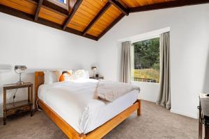 a bedroom with a large bed and a window at Queenstown Lakefront Dream 4 Bed in Queenstown +25 photos
