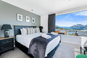 a bedroom with a bed and a large window at Skye Horizons in Queenstown