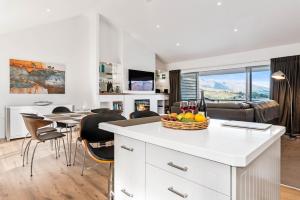 a kitchen and living room with a table with a basket of fruit at Skye Horizons in Queenstown