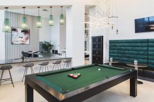 a pool table in a room with a bar at Tucker at Palmer Dadeland Miami in Miami