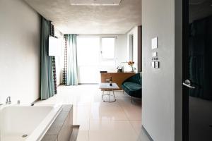 a bathroom with a tub and a couch and a window at Hotel The Designers Hongdae in Seoul +37 photos