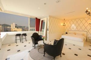 a hotel room with a bed and a table and chairs at Hotel The Designers Hongdae in Seoul