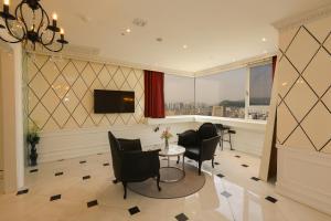 a living room with a table and chairs and a window at Hotel The Designers Hongdae in Seoul