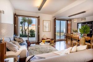 a living room with a white couch and a dining room at Beachside Villa 5 Bdr 6 Baths Sleeps 9plus ppl in Aljezur