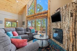 a living room with a couch and a fireplace at Gold Nugget Lodge Near Deadwood on 5 Wooded Acres! in Lead