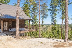 a log cabin in the woods with trees at Gold Nugget Lodge Near Deadwood on 5 Wooded Acres! in Lead