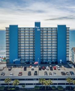 a large blue building with cars parked in a parking lot at 0911 Waters Edge Resort condo in Myrtle Beach