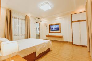 sypialnia z dużym białym łóżkiem i oknem w obiekcie Bảo Châu Hạ Long Hotel w Ha Long
