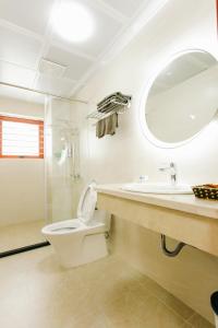ein Bad mit einem WC, einem Waschbecken und einer Dusche in der Unterkunft Bảo Châu Hạ Long Hotel in Hạ Long