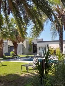 a house with a pool and palm trees at Reina Mora Hotel in La Rioja