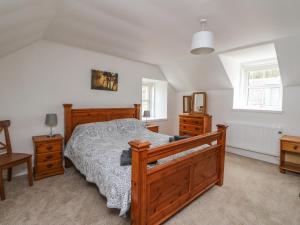 una camera con letto in legno e 2 cassettiere di Storkery Cottage ad Aberdeen