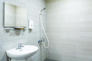 a white bathroom with a sink and a shower at Anping OAOA Homestay in Anping