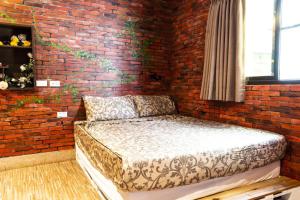 a brick wall with a bed in a room at Anping OAOA Homestay in Anping