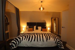 a bedroom with a zebra print bed with two lamps at The Breathe Residence in Rhyl