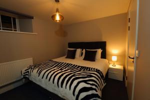 a zebra print bed in a bedroom with a lamp at Declaration Suite in Rhyl