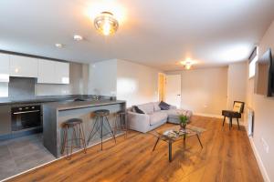 a kitchen and living room with a couch and a table at Strength Rooms in Rhyl