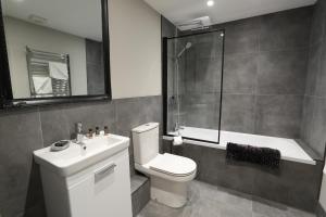 a bathroom with a toilet and a shower and a sink at Strength Rooms in Rhyl