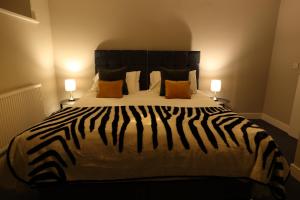a zebra print bed in a bedroom with two lamps at Strength Rooms in Rhyl