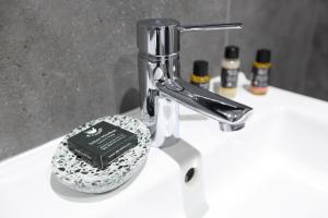 a bathroom sink with a faucet with a book on it at The Poppy Fields Abode in Rhyl