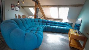 a large blue couch in a living room at The Sigma Penthouse in Rhyl