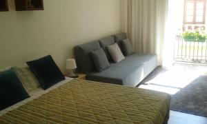 sala de estar con sofá y cama en Lovely Apartment @ Aveiro's Downtown, en Aveiro