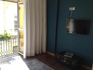 Habitación con TV de pantalla plana en una pared azul. en Lovely Apartment @ Aveiro's Downtown, en Aveiro
