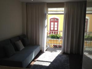 a living room with a couch in front of a window at Lovely Apartment @ Aveiro's Downtown in Aveiro