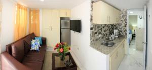 een woonkamer met een bank en een keuken bij 2 Guests 1bed Studio 3min To Beach And Main Street in Sosúa