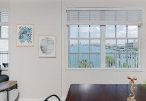a living room with a window and a wooden table at NEW Beach Condo 5 min walk to the Beach Sleeps 9 in Clearwater Beach