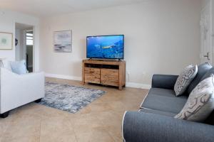 a living room with a couch and a flat screen tv at NEW Beach Condo 5 min walk to the Beach Sleeps 9 in Clearwater Beach +26 photos
