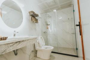 y baño con ducha, aseo y lavamanos. en Bảo Châu Hạ Long Hotel en Ha Long
