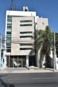 un edificio con una palmera delante de él en Room in Guest room - Habitacion Tipo Hotel En Obispado, en Monterrey