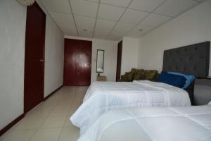 una habitación de hotel con 2 camas y una silla en Room in Guest room - Habitacion Tipo Hotel En Obispado, en Monterrey