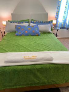 een bed met een groene deken en kussens erop bij Stylish 2R-2B Apt Near the Beach and Main Street in Sosúa