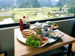 a table with two plates of food and a window at Cherry homestay in Ninh Binh