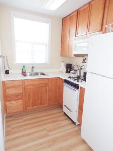 una cucina con mobili in legno e un frigorifero bianco di Shoreline Cottages a Fort Bragg