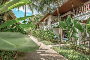 ein Haus mit Palmen davor in der Unterkunft Nai Yang Beach Resort and Spa in Nai Yang Beach