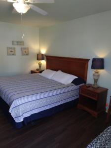 sypialnia z dużym łóżkiem i 2 lampkami na stołach w obiekcie Anglers Hideaway Cabins w mieście Mead