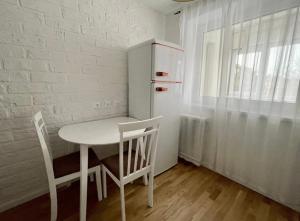 a kitchen with a table and two chairs and a refrigerator at N-J APARTANENT in Narva-Jõesuu