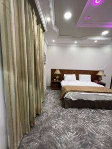 a hotel room with a bed and curtains at سويت ان العلا للشقق المفروشة الخاصة Sweet In alula Apartments and organizing tours in Al-ʿUla