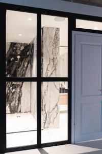 a window with a blue door and a marble wall at Exclusive Jacuzzi Apartaments Klaipėda in Aukštkiemiai