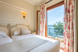 a bedroom with a bed and a large window at Hotel Cala Fornells in Paguera