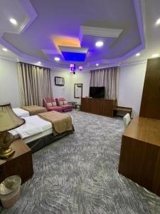 a hotel room with a bed and a purple ceiling at سويت ان العلا للشقق المفروشة الخاصة Sweet In alula Apartments and organizing tours in AlUla