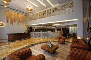 eine Lobby mit Sofas, einem Tisch und einer Bar in der Unterkunft Bizz The Hotel in Rajkot