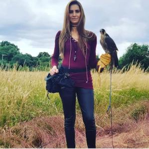 a woman standing in a field with a bird on a pole at GORGEOUS FlatC Central London Liverpool St Station in London