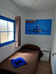 a bedroom with a bed and a picture of a person in a canoe at APARTAMENTO LA SAMA in Caleta de Sebo