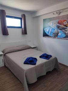 a bedroom with a bed with two blue towels on it at APARTAMENTO LA SAMA in Caleta de Sebo