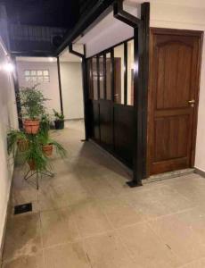 a hallway with a wooden door and potted plants at Los Naranjos Departamentos 2 in Concepción