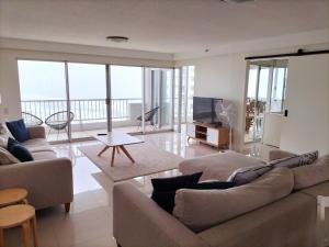 Una sala de estar con dos sofás y un televisor. en Marriner Views, en Gold Coast